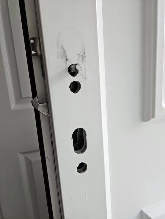 Damaged uPVC door edge with the lock keep holes exposed