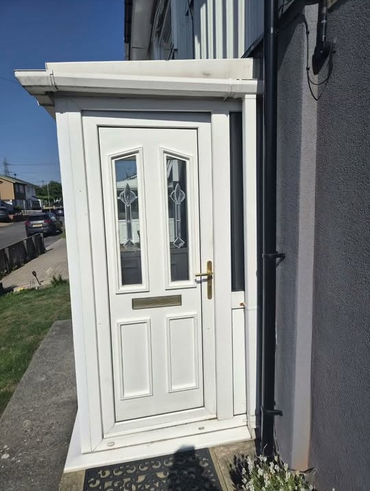 White uPVC front door with decorative glazing inside a white uPVC porch