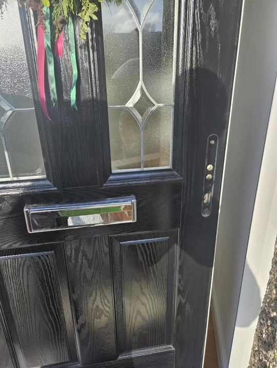 Black composite door with chrome letterplate and leaded glazing